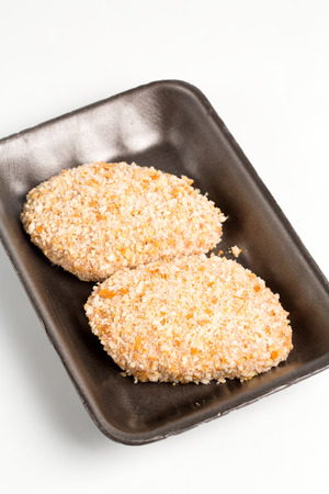 Raw food, chicken cutlet ready for prepare. Minced chicken portion in plastic box on white background.の写真素材