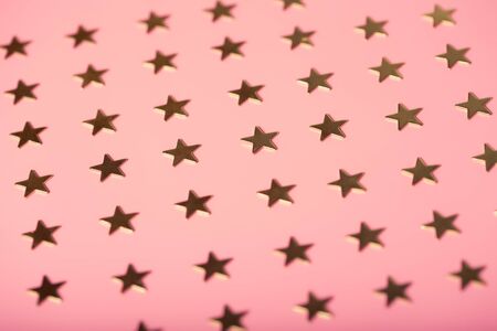 Pinky holiday background with golden stars, festive conceptの写真素材