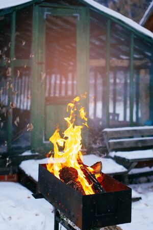 Logs burning in a brazier on backyard outdoors in wintertime, cozy winer holidaysの写真素材