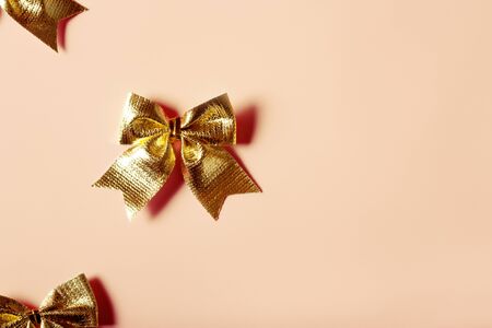 Pink celebration background with golden bows. Festive present concept, flat lay.の写真素材