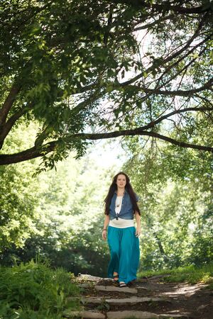 Young beautiful pregnant woman posing in park outdoorsの写真素材