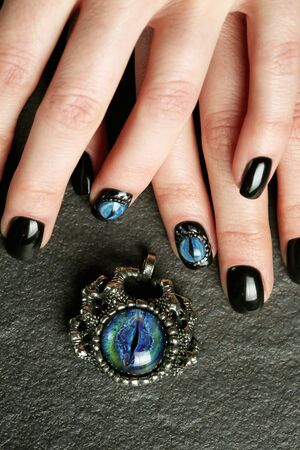 Dark fantasy nail art on manicured hands close-up, gothic styleの写真素材