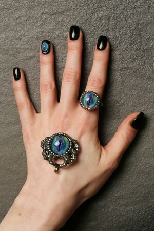 Unusual fantasy nail art and ring on manicured hands close-up, gothic styleの写真素材