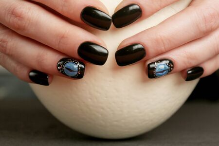 Dark fantasy nail art on manicured hands close-up, gothic styleの写真素材
