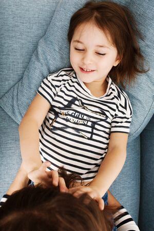 Cute little girl 4-5 years old having fun with her mom and smiling, top view. Happy childhood.の写真素材