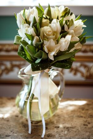 Beautiful romantic bouquet of white flowers in luxury interior, wedding day bridal flowersの写真素材