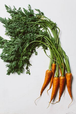 Fresh organic farmer carrots on white background, close-up, top view. Natural vegetables.の写真素材