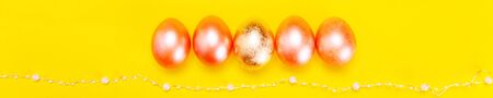 Trendy minimalistic concept of easter holiday with pearl colored eggs over bright yellow background, flat lay, bannerの写真素材