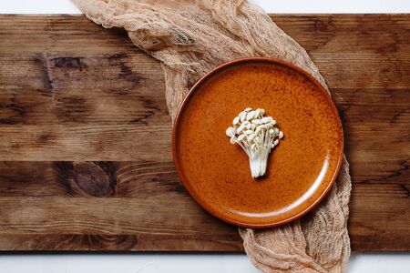Enoki, Enokitake, Flammulina velutipes, edible mushroom popular in Japanese cuisine. Heap of little white mushrooms served on ceramics plate, dieting, close-up.の写真素材