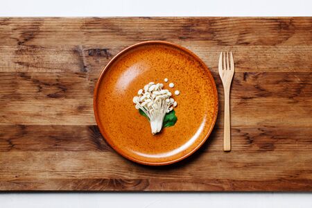 Enoki, Enokitake, Flammulina velutipes, edible mushroom popular in Japanese cuisine. Heap of little white mushrooms served on ceramics plate, dieting, close-up.の写真素材
