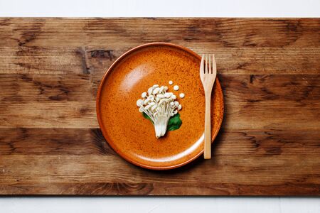 Enoki, Enokitake, Flammulina velutipes, edible mushroom popular in Japanese cuisine. Heap of little white mushrooms served on ceramics plate, dieting, close-up.の写真素材