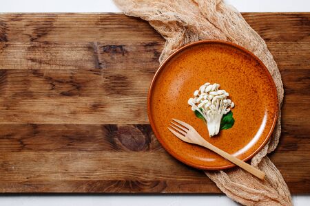 Enoki, Enokitake, Flammulina velutipes, edible mushroom popular in Japanese cuisine. Heap of little white mushrooms served on ceramics plate, dieting, close-up.の写真素材
