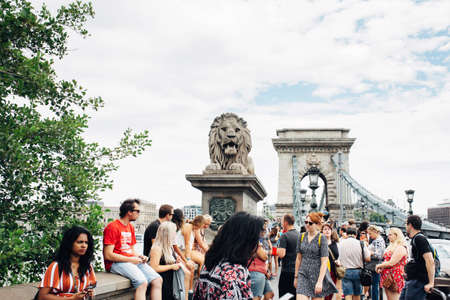 BUDAPEST, HUNGARY - July 23, 2019 - Famous Szechenyi chain bridge with Lion sculpture full of tourists in day time in summerのeditorial素材