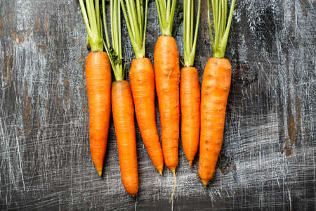 Close up of young fresh organic farmer carrots on rustic background, top view. Natural vegetables.の写真素材