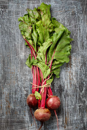 Bundle of fresh organic farmer young beetroots with haulm on dark scratched background, top view. Natural organic vegetables.の写真素材