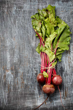 Bundle of fresh organic farmer young beetroots on dark scratched background, top view. Natural organic vegetables.の写真素材