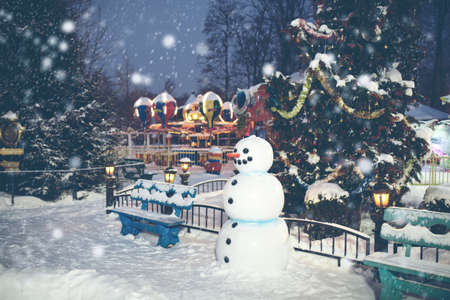 Magical Christmas background with snow and funny snowman in winter amusement parkの写真素材
