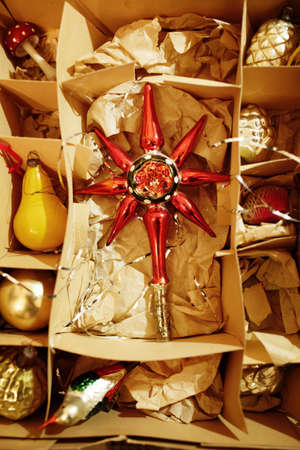Open cardboard box with vintage Christmas decorations made of glass, top view, selective focusの写真素材