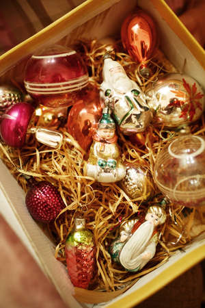 Open cardboard box with vintage Christmas decorations made of glass, top view, selective focusの写真素材