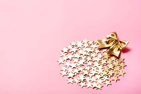 Creative Christmas arrangement with golden stars in a shape of bauble on pink background, glamor presentconceptの写真素材