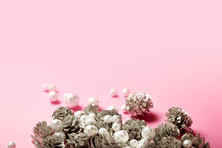 Christmas festive composition with silver pine cones and small glitzy balls on bright pink background, copy spaceの写真素材
