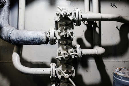 Old aged gray pipes and valves close-upの写真素材