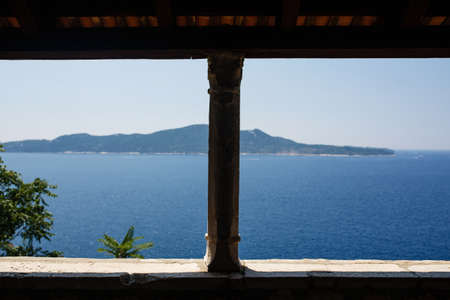 View on the blue shiny Adriatic sea from villa terrace in Trsteno Arboretum, selective focus on the stone columnの写真素材