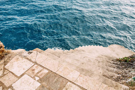 Stone stairs to cave in the cliff in the Adriatic sea in Makarska, Croatia, vacation and holidays backgroundの写真素材