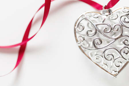 Saint Valentine day greeting card, beautiful silver heart with ribbon on white background