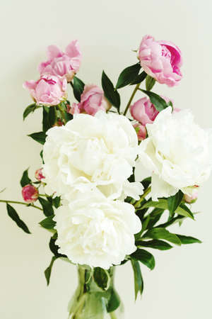 Sloppy flower bouquet of pink and white peonies flowers over pastel background, spring and summer season flowersの写真素材