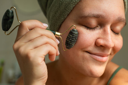 A full facial portrait of a woman holding a stone massager, captured from a distance. Soft lighting...