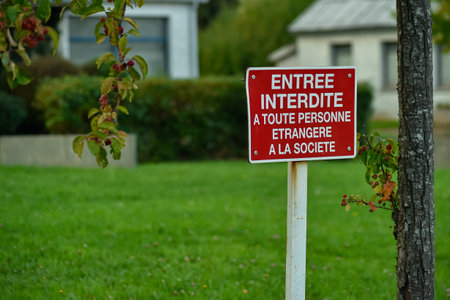 The red No Entry sign in French, meaning Entry forbidden to any person strange to the society. Framed by autumn foliage.の写真素材