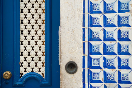Striking blue door framed by classic Lisbon Azulejo tiles. Captures Portuguese charm, architectural detail, and vibrant city street aesthetics.の写真素材