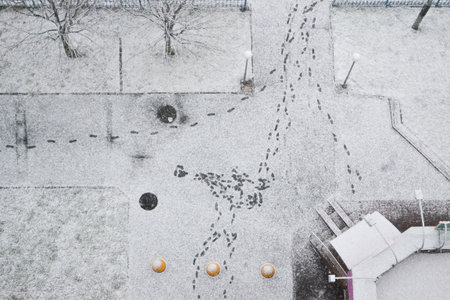 An overhead shot of a snowy pedestrian street in Kyiv, Ukraine, dominated by various footprints creating a complex pattern in the fresh white snow. Captures the essence of cold winter weather.の写真素材