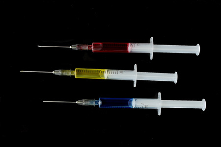 Multicolor medicine hypodermics on black background. Healthcare, addiction.の写真素材