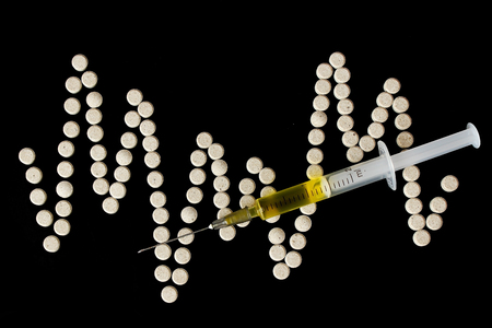 Multicolor medicine hypodermics on black background. Healthcare, addiction.の写真素材