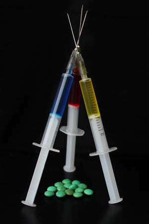 Multicolor medicine hypodermics on black background. Healthcare, addiction.の写真素材