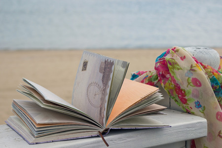 Sunglasses, book and scarf in the beachの写真素材