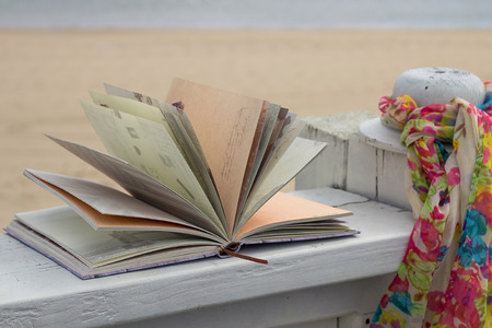Book and scarf in the beach. Romance in the seaの写真素材