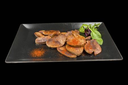 Tasty veal tongue with spices in ? plate, isolated on black backgroundの写真素材