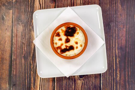 Gourmet dessert of rice with milk, on a wooden table. Top view