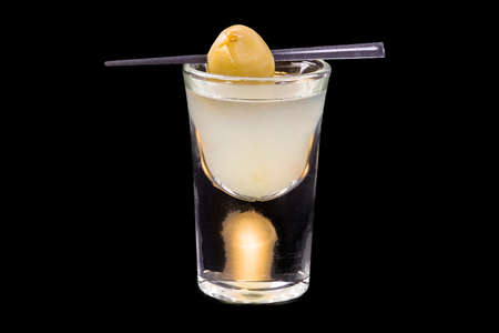 Russian breakfast cocktail in a shot glass, isolated on black background.
