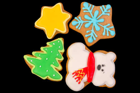Group of tasty christmas print cookies isolated on black background.