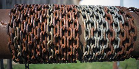 Close up of rusty chain wrapped around tube on old water well.の写真素材