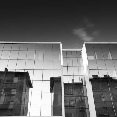 Past see present, reflection of an old building in a new buildingの写真素材