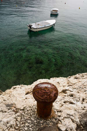 Rabac Croatia,stone coast, bollard, two boatsの写真素材