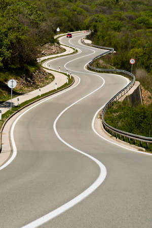 tortuous road full of bends in the mountain meadowsの写真素材