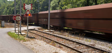 Caution going train! Motion blurred train passing a railroad crossing, Croatiaの写真素材