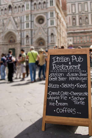 Black board with a menu restaurant in a typical traditional square in Florenceの写真素材