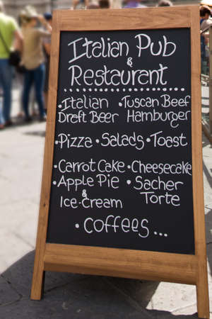 Black board with a menu restaurant in a typical traditional square in Florenceの写真素材